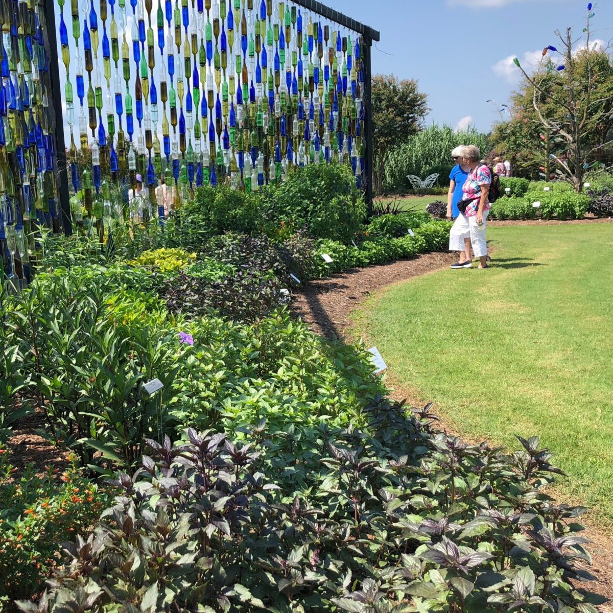 Visitors exloring the gardens at the bottle wall 